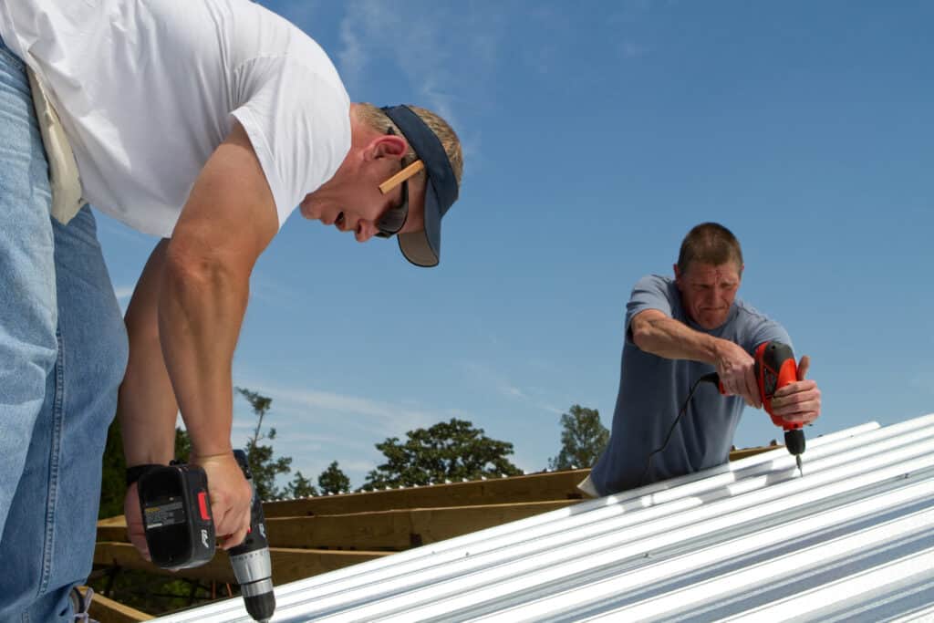 roofing crew works on installing metal roof