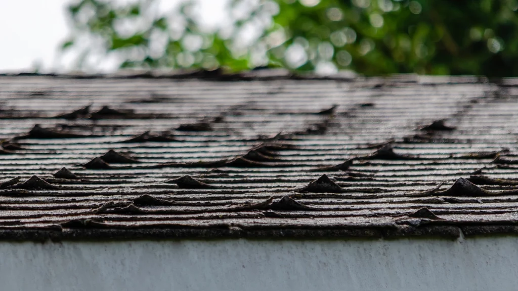 close up of curling shingles in need of emergency roof repair