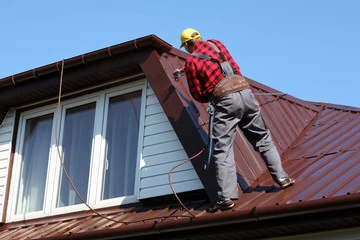 Installation of a maroon metal roof 