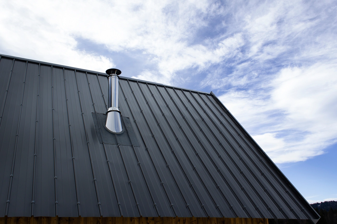Close up if black standing seam metal roofing system installed on home
