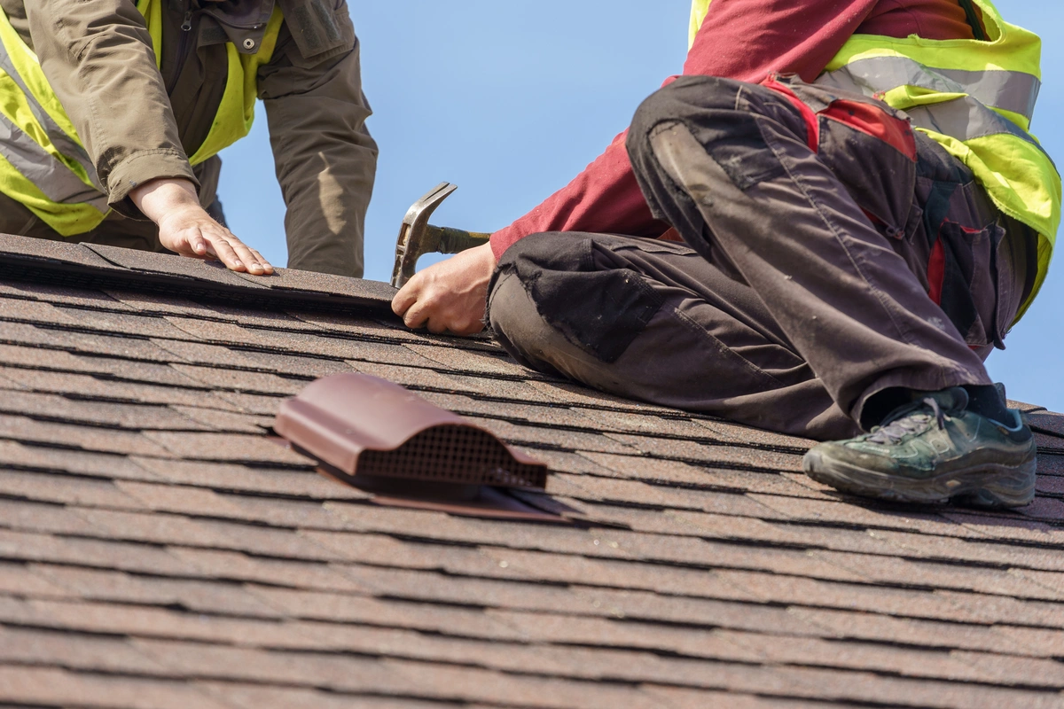 Closeup look at roofing contractors installing roof shingles