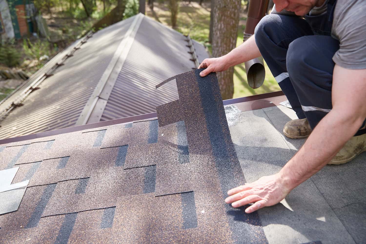 A worker demonstrating how to install architectural shingles