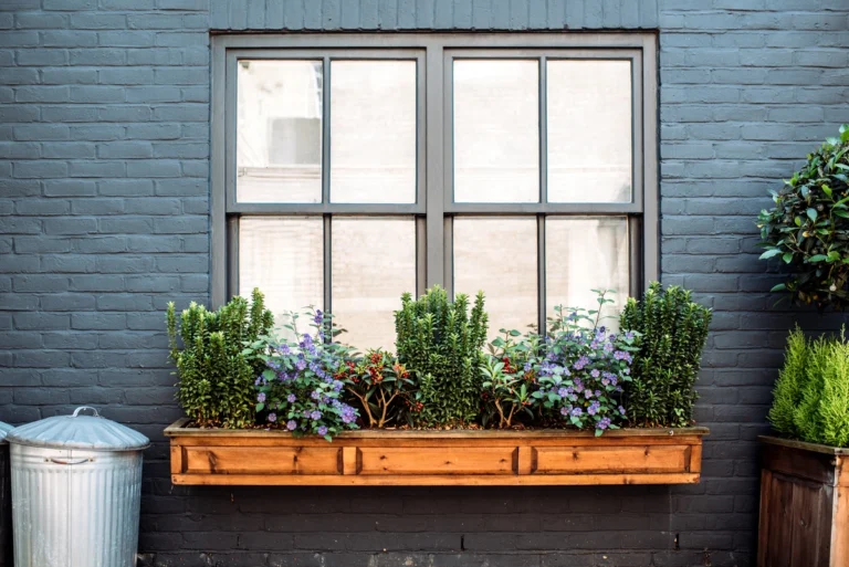 window replacement-exterior window on a black brick wall with a wooden plant box