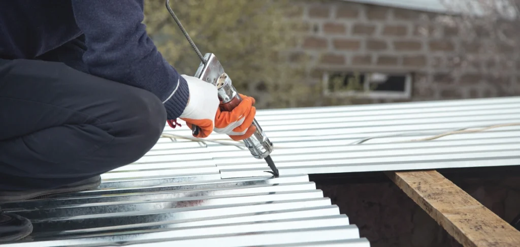 metal roof cost-close up of tech using hand tools to install metal roofing