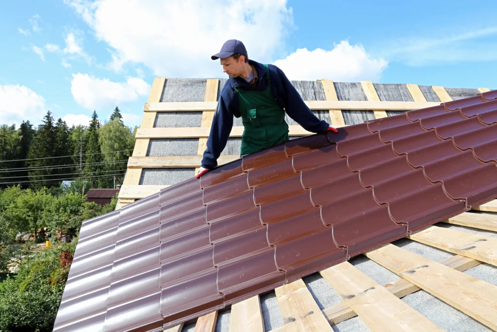 metal roof cost-roof tech installing dark red metal roofing panel