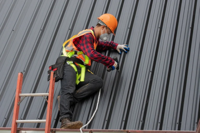 metal roof cost-roof tech near ladder installing metal roofing materials