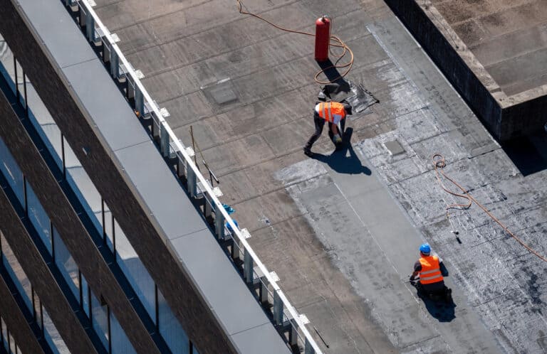 flat roof leak repair-two techs repairing a commercial flat roof