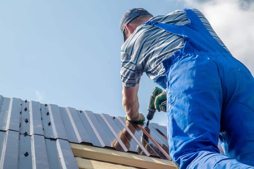 metal roof installation mistakes-image of a roof tech installing metal roofing materials