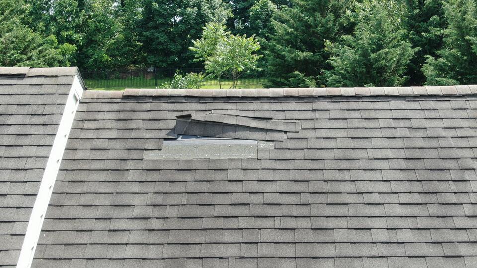 missing shingles-gray shingled roof with several strips of missing shingles