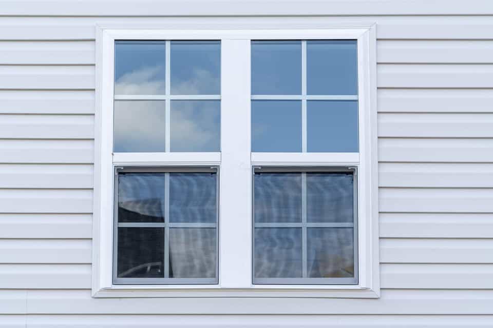 vinyl windows-double hung windows on a white sided house